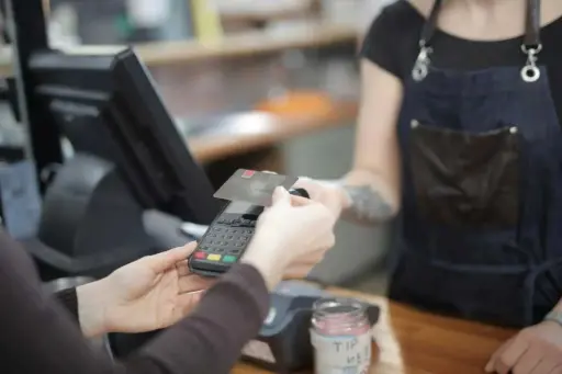 Paiement par carte bancaire sur un TPE dans un restaurant, illustrant l'acceptation des titres-restaurant