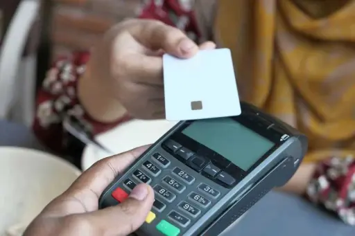 Technicien effectuant une mise à jour par téléparamétrage sur un terminal de paiement TPE pour l'acceptation des titres-restaurant