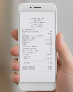 Main tenant un smartphone affichant un ticket de caisse numérique, illustrant la dématérialisation des reçus de dons par e-mail