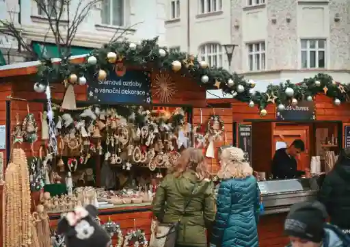 Stand de marché de Noël avec clients, illustrant l'usage d'un TPE SumUp ou Zettle pour encaisser lors d'événements saisonniers