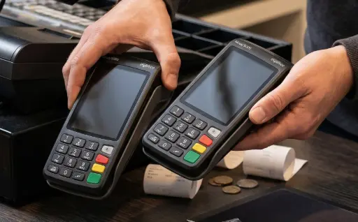 Deux terminaux de paiement TPE côte à côte sur un comptoir, illustrant la technique de substitution frauduleuse de terminal par des escrocs