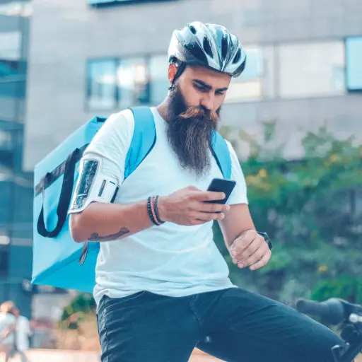 Livreur à vélo utilisant le TPE Ingenico Axium EX6000 pour encaisser un paiement mobile